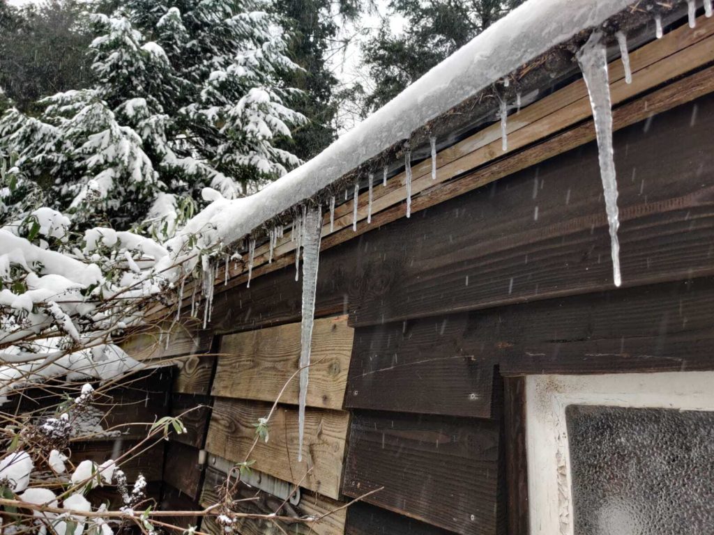 Winters weer houdt aan, ijspegels aan dakgoot in Nederland